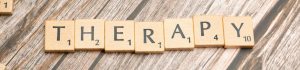 Scrabble tiles spelling the word “therapy,” representing the importance of personal therapy for trainee counsellors in Surrey.