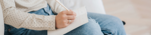 Woman sitting, writing notes during a reflective learning session, symbolising the journey of counselling training and personal therapy.
