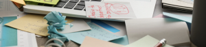 Cluttered desk with notes and post-its, representing stress, overwhelm, and the process of finding calm.