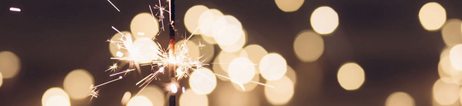 Bright sparkler glowing against a dark background, symbolising New Year resolutions, fresh starts, and positive change.