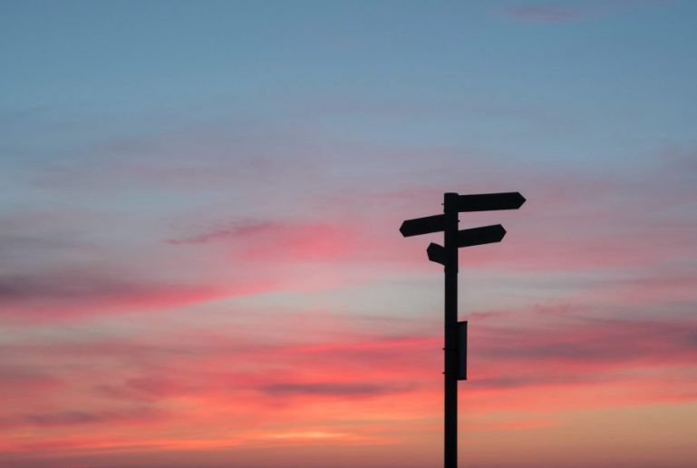 Sunset with a signpost pointing in different directions, symbolising the choices and guidance available through counselling.